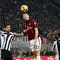 Pemain AC Milan, Alessio Romagnoli menyundul bola yang berusaha direbut pemain Juventus, Sami Khedira pada lanjutan Serie A Italia di Stadion San Siro, Sabtu (28/10). Lewat Gonzalo Higuain, Juve memetik kemenangan dua gol tanpa balas. (AP/Antonio Calanni)