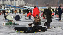 Peserta saat mengikuti lomba memancing ikan trout di sungai yang membeku di Hwacheon, Korea Selatan (6/1). Kontes ini merupakan bagian dari festival es tahunan yang menghasilkan lebih dari 1.000.000 pengunjung setiap tahunnya. (AP Photo/Ahn Young-joon)