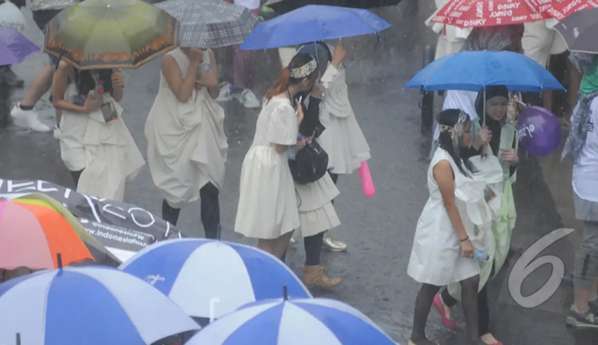Sunday Dress Up dikemas dengan konsep fun walk. Meski diguyur hujan para peserta tetap antusias, Bundaran HI, Jakarta, Minggu (1/2/2015). (Liputan6.com/Herman Zakharia)