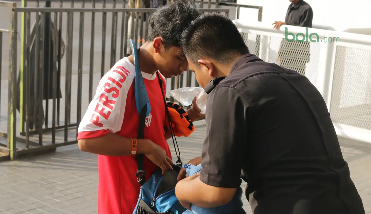 Petugas memeriksa tas suporter sebelum menonton laga Piala AFC 2018 antara Persija Jakarta vs Song Lam Nghe An di Stadion Utama GBK, Rabu (14/3/2018). Panpel menjual sekitar 65.000 lembar tiket. (Bola.com/Surya Bima Mahendarta)