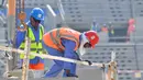Pekerja menyelesaikan pembangunan Stadion Lusail di Qatar, Jumat (20/12). Lusail akan menjadi stadion untuk partai pembuka dan penutup piala dunia 2022 di Qatar. (AFP/Giuseppe Cacace)
