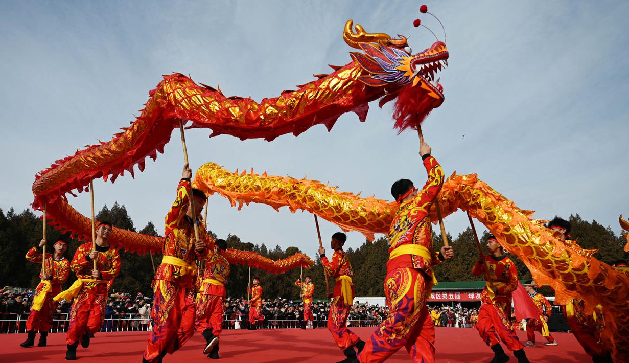 Para penari naga tampil di sebuah pameran kuil pada hari kedua Tahun Baru Imlek Naga di Beijing pada 11 Februari 2024. (GREG BAKER/AFP)