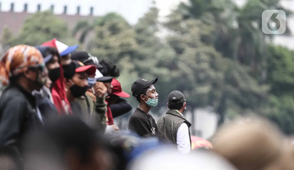 Massa aksi menolak omnibus law saat unjuk rasa di area sekitar Patung Kuda, Jakarta Pusat, Selasa (13/10/2020). Massa mulai berdatangan sejak pukul 11.10 WIB.  Kedatangan massa seiring dengan mobil komando aksi yang juga tiba di lokasi. (Liputan6.com/Faizal Fanani)