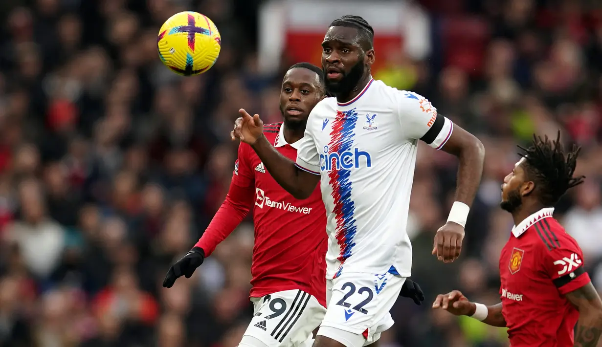 Pemain Crystal Palace Odsonne Edouard (tengah) berduel memperebutkan bola dengan pemain Manchester United Aaron Wan-Bissaka (kiri) dan Fred pada pertandingan sepak bola Liga Inggris di Stadion Old Trafford, Manchester, Inggris, 4 Februari 2023. Manchester United mengalahkan Crystal Palace dengan skor 2-1. (AP Photo/Dave Thompson)
