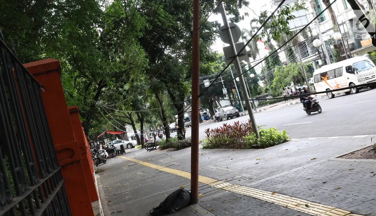 Kondisi tiang yang miring di Jalan Gedung Kesenian, Jakarta, Jumat (22/2). Keberadaan tiang miring tersebut membahayakan keselamatan pejalan kaki karena kabel yang turut menjuntai hingga ke bawah. (Liputan6.com/Immanuel Antonius)