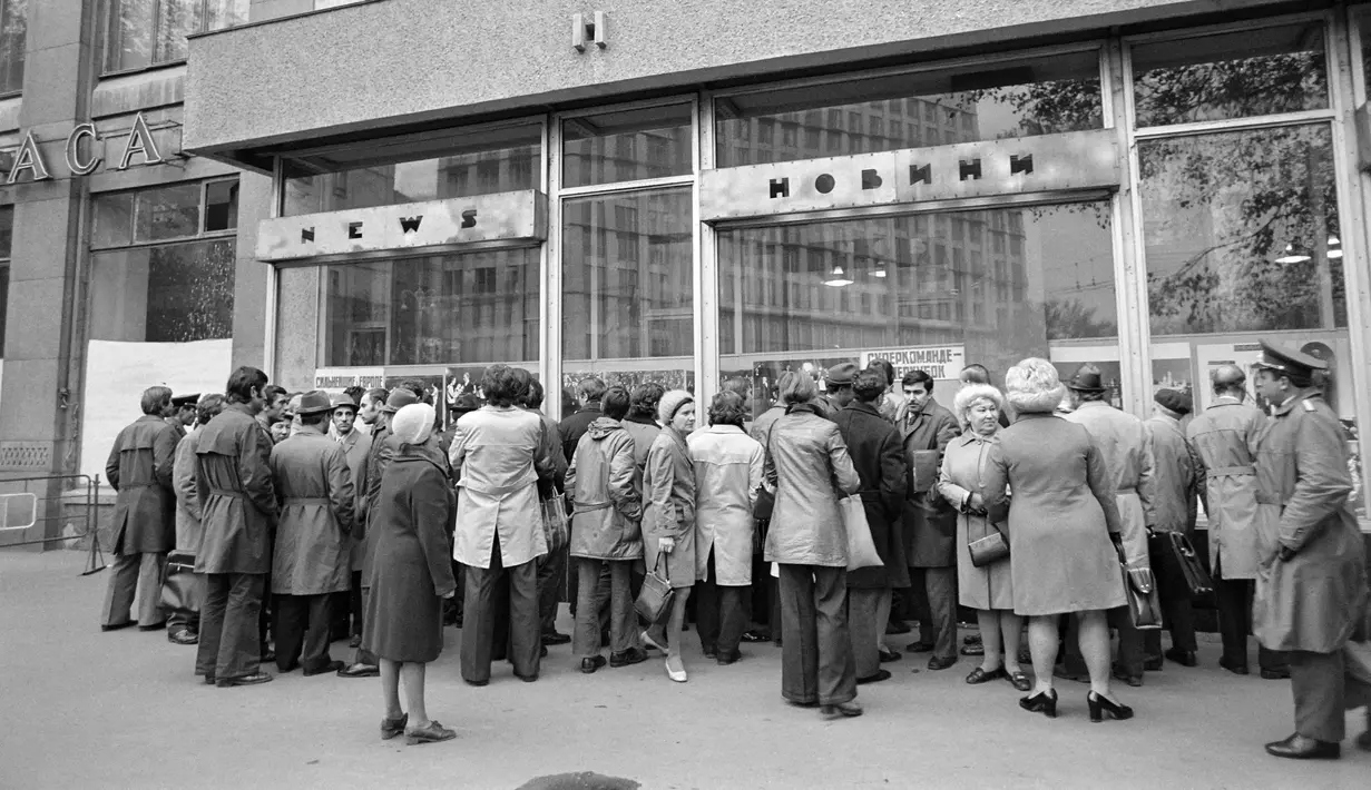 Orang-orang berkumpul untuk membaca berita di depan etalase toko pada masa Uni Soviet di Jalan Khreshchatyk, Kiev, 18 Oktober 1975. (Pierre GUILLAUD/AFP)