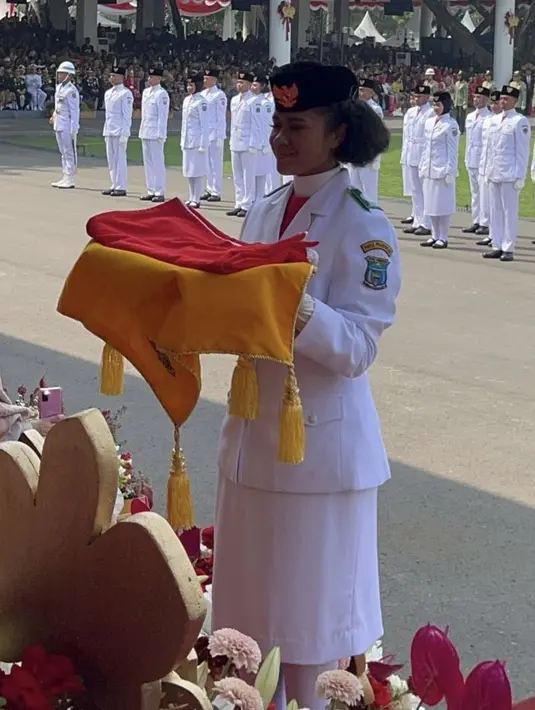 Saat bertugas menjadi pembawa baki, Lilly tampil memesona dengan pakaian paskibraka serba putih dari atasan jas dan roknya. [Instagram/@erinagudono]