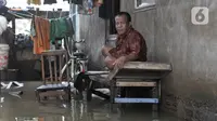 Aktivitas warga saat banjir merendam RT 10/RW 05, Kampung Sawah, Kelurahan Rawa Terate, Cakung, Jakarta Timur, Kamis (20/2/2020). Banjir diperparah dengan adanya pembangunan apartemen di kawasan Kelapa Gading sehingga aliran air tidak lagi mengalir ke laut. (merdeka.com/Iqbal Nugroho)