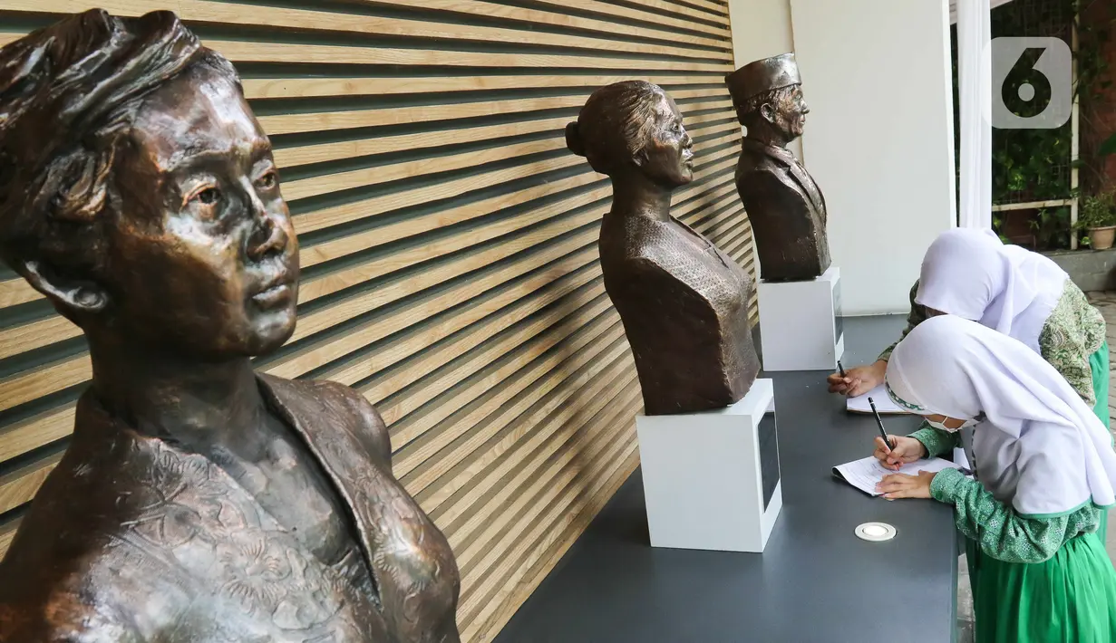Pelajar mencatat dan mengamati patung pahlawan di Museum Sumpah Pemuda, Jakarta, Kamis (27/10/2022). Jelang peringatan Hari Sumpah Pemuda, museum tersebut ramai dikunjungi pelajar sebagai tujuan wisata edukasi yang memberikan wawasan tentang hari bersejarah ikrar Sumpah Pemuda saat Kongres Pemuda II yang digelar pada 27-28 Oktober 1928. (Liputan6.com/Herman Zakharia)