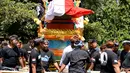 Warga membawa peti mati berisi jenazah Aipda Wayan Sudarsa, polisi korban pembunuhan pasangan bule, di Jimbaran, Bali, Minggu (21/8). Warga Desa Adat Jimbaran dan pecalang pun turut serta mengantarkan korban yang akan diaben. (SONNY Tumbelaka/AFP)
