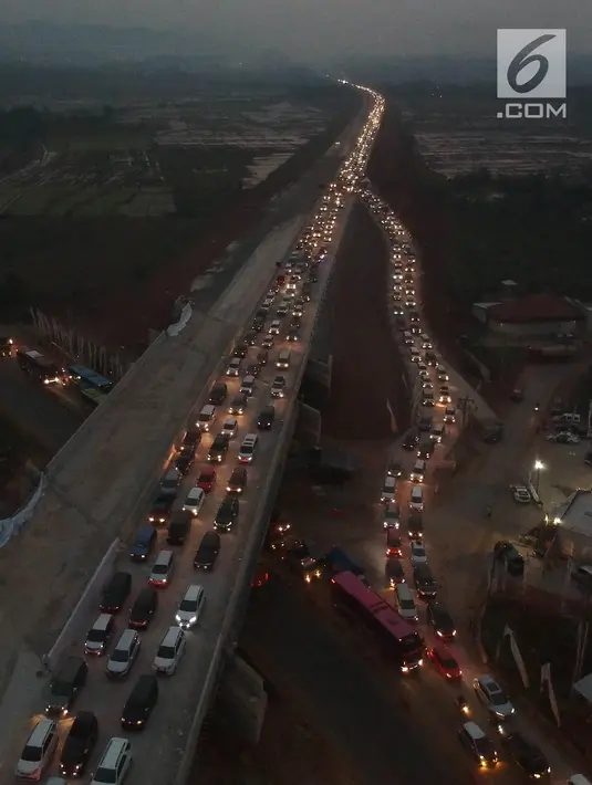 Foto udara kepadatan pemudik untuk keluar dari ruas Tol Batang-Semarang menuju jalur Pantura Batang-Kendal di Kali Kuto, Gringsing, Kabupaten Batang, Jawa Tengah, Senin (11/6). (Liputan6.com/Arya Manggala)