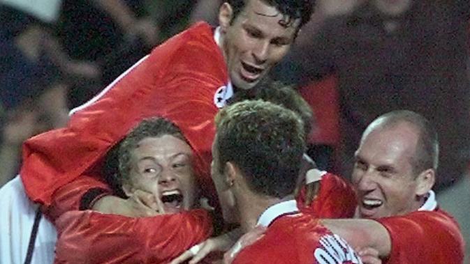 Striker MU, Ole Gunnar Solskjaer bersama rekan-rekannya berselebrasi usai mengalahkan Bayern Munchen di final Liga Champions di Stadion Camp Nou, Barcelona pada 26 Mei 1999. (AFP Photo/Eric Cabanis)