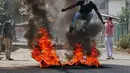 Demonstran melompati api saat aksi di Srinagar, India, Selasa (13/9). Mereka protes karena pembunuhan yang terjadi di Kashmir belum lama ini. (REUTERS / Danish Ismail)