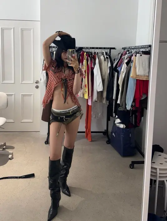 Salah satu foto memperlihatkan Jennie bergaya koboi dengan crop top dan tren celana mikro. Penampilannya makin stylish dengan leather high boots dan topi koboi.  [@jennierubyjane].