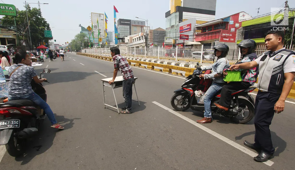 Petugas menegur pengendara motor di arena Car Free Day (CFD) di Jalan Warung Jati Barat, Jakarta, Minggu (17/9).  Beberapa pengendara motor terlihat bebas menerabas jalan yang dipenuhi orang yang berolahraga dan berjualan. (Liputan6.com/Immanuel Antonius)