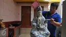 Seorang umat membersihkan patung dewa-dewi saat ritual cuci dewa di Klenteng Dharma Bhakti,Jakarta, minggu, (31/1). Pencucian sejumlah patung ini dilakukan guna menyambut tahun baru imlek China 2567. (Liputan6.com/Gempur M Surya)