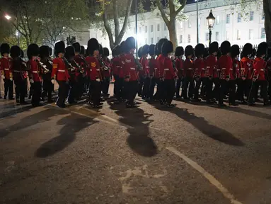 Anggota militer berbaris di dekat Istana Buckingham di pusat kota London, Selasa, 2 Mei 2023 saat latihan untuk penobatan Raja Charles III yang akan berlangsung di Westminster Abbey pada 6 Mei. (AP Photo/Andreea Alexandru)