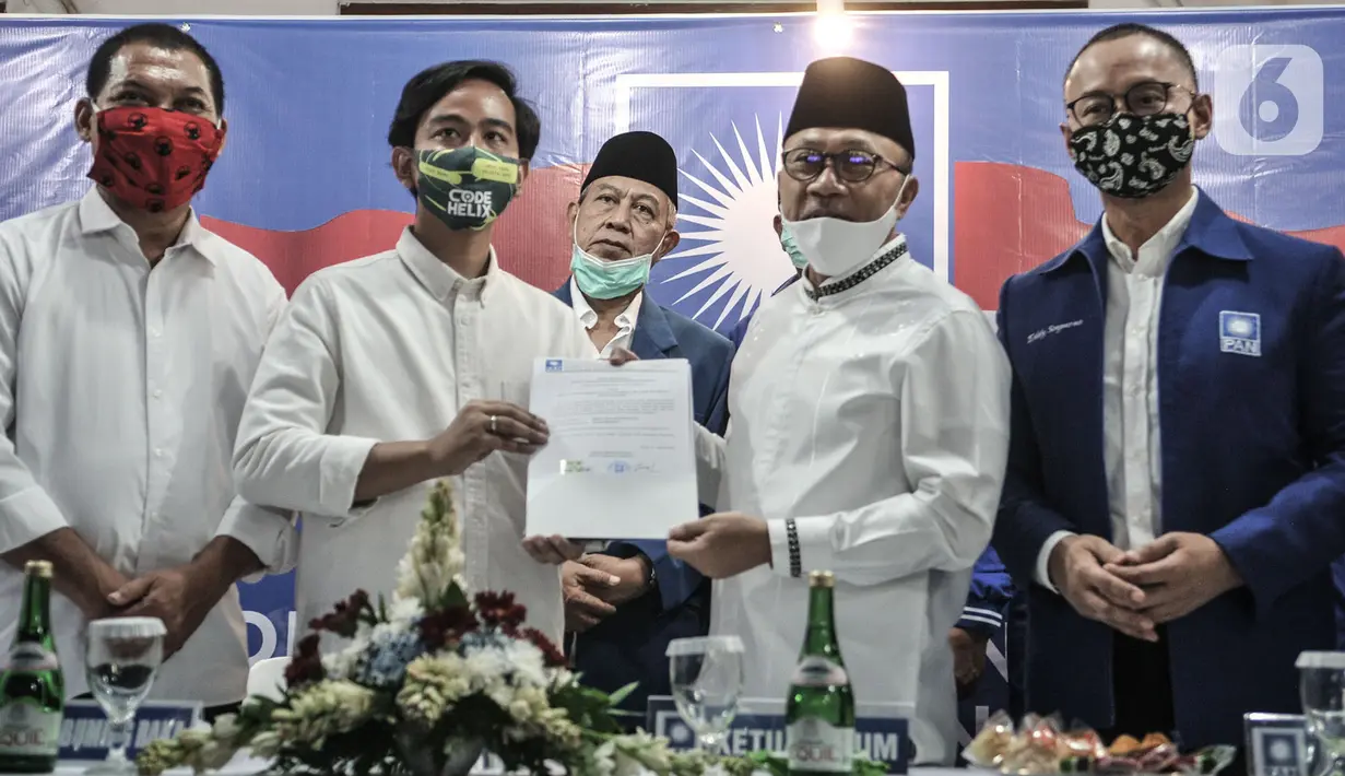 Ketua Umum PAN Zulkifli Hasan menyerahkan dokumen dukungan kepada bakal calon Wali Kota Solo Gibran Rakabuming Raka saat menggelar pertemuan di Jakarta, Rabu (12/8/2020). PAN telah resmi memberikan dukungannya kepada Gibran Rakabuming pada Pilkada Solo 2020. (merdeka.com/Iqbal Nugroho)