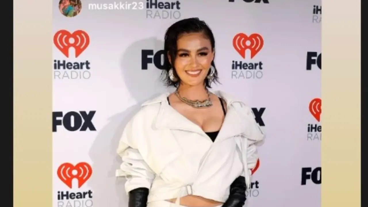 Agnez Mo Bergaya Monokrom dan Tenteng Tas Gucci Berisi Paspor Pacarnya di iHeart Radio Music Awards 2024.