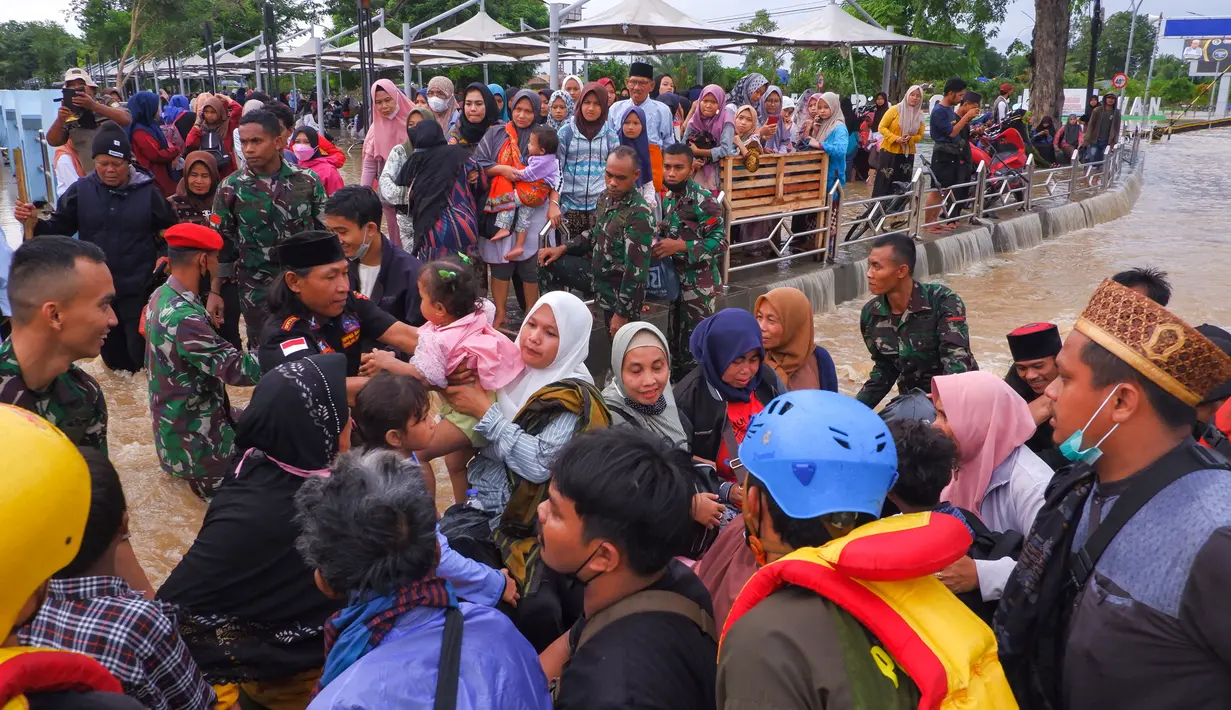 Anggota tim SAR membantu warga mengungsi pasca banjir di Serang, Provinsi Banten (1/3/2022).  Berdasarkan data sementara dari Polres Serang Kota, ada 20 titik banjir yang merendam pemukiman warga di Kota Serang. (AFP/Dziki Oktomauliyadi)