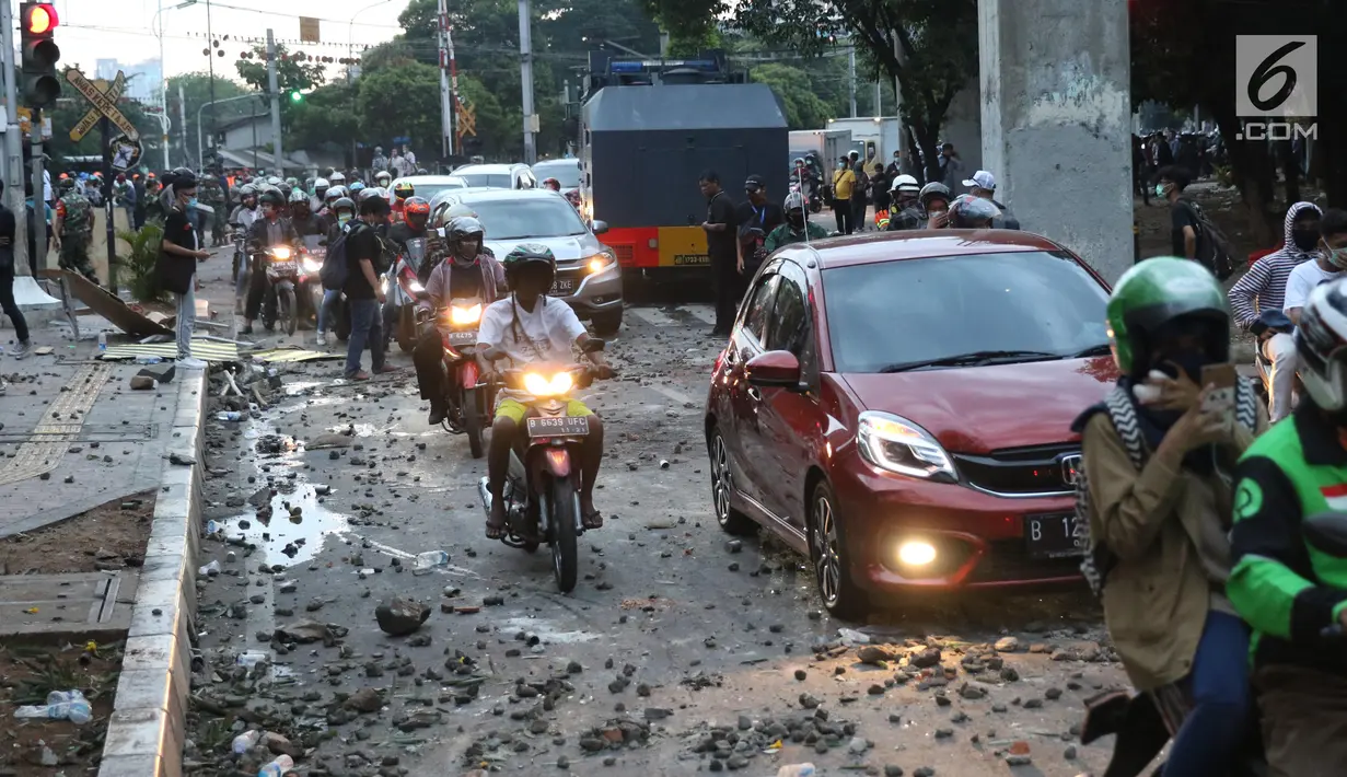 Kendaraan melintasi jalan di sekitar Stasiun Palmerah, Jakarta Barat, Senin (30/9/2019). Jalur di kawasan itu telah dibuka, namun kendaraan harus berhati-hati karena banyaknya batu sisa bentrokan massa di belakang gedung DPR yang berakhir ricuh. (Liputan6.com/Angga Yuniar)
