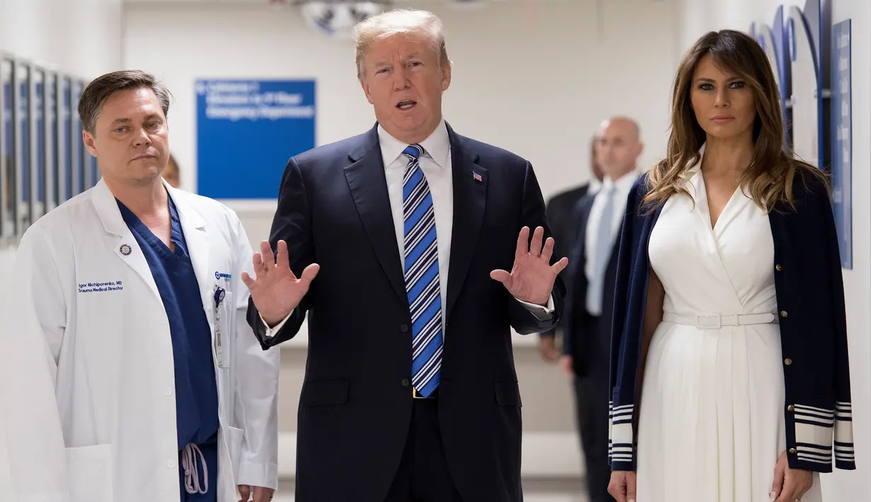 Presiden AS Donald Trump (tengah) didampingi istrinya Melania Trump (kanan) dan dokter Igor Nichiporenko (kiri) saat mengunjungi rumah sakit Broward Health North Pompano Beach, Florida (16/2). (AFP Photo/Jim Watson)
