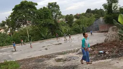 Anak-anak bermain di sekitar RPTRA Pelangi Cipedak di Jakarta, Senin (18/3). Terhentinya pembangunan RPTRA yang telah tiga kali mangkrak dikeluhkan warga karena molor dari target yang ditentukan. (Liputan6.com/Immanuel Antonius)
