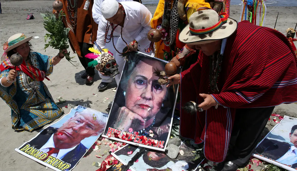 Dukun Peru melakukan ritual prediksi pada poster bergambar Capres AS dari Partai Demokrat, Hillary Clinton dan rivalnya dari Partai Republik, Donald Trump menjelang pemilihan presiden AS, di Lima, Peru, Senin (7/11). (REUTERS/Mariana Bazo)