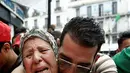 Demonstran memeluk seorang wanita saat berdemonstrasi di Aljir, Aljazair, Jumat (19/4). Para pengunjuk rasa yang sebagian besar anak muda meneriakkan slogan-slogan termasuk "Viva Aljazair, mereka semua harus pergi!". (REUTERS/Ramzi Boudina)