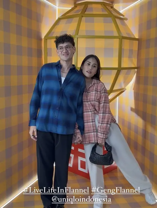 Tarra Budiman mengenakan flannel biru dipadukan celan hitam. Sementara sang istri, Gya mengenakan flannel warna pink dipadukan celana putih serasi dengan sneakersnya. [@gyaps]