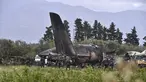 Petugas keamanan dan tim penyelamat berjaga di sekitar reruntuhan pesawat tentara Aljazair yang jatuh di dekat pangkalan udara Boufarik, Aljazair (11/4). Insiden ini menewaskan 257 orang yang berada di dalam pesawat tersebut. (AFP Photo/Ryad Krmadi)