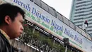 Salah satu pengguna jalan MH Thamrin memerhatikan tingkah nekat orang yang tidak dikenal di atas JPO di sekitar Bundaran HI, Jakarta, (25/7/2014). (Liputan6.com/Faizal Fanani)