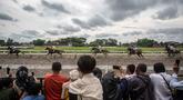 Orang-orang menonton balapan kuda dalam ajang Piala Raja Hamengku Buwono X 2025, kejuaraan balap kuda nasional tahunan yang memperebutkan trofi Sultan Hamengku Buwono X, di lintasan Sultan Agung, Bantul, Yogyakarta, pada Minggu 9 November 2025. Indonesia's Horse Racing (IHR) Piala Raja Hamengku Buwono (HB) X 2025 sukses digelar di Lapangan Pacuan Kuda Sultan Agung, DI Yogyakarta, Minggu (9/11/2025). (DEVI RAHMAN/AFP)