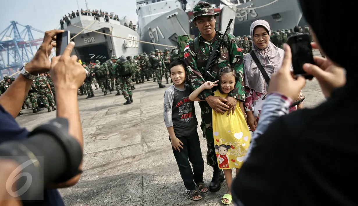 Prajurit TNI yang tergabung dalam Satgas Perbatasan berfoto bersama keluarga sebelum naik KRI Teluk Ratai 509 di Dermaga Mako Kolinlamil, Jakarta, Rabu (27/1). 1300 prajurit diberangkatkan menjaga perbatasan darat RI-Malaysia. (Liputan6.com/Faizal Fanani)