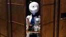 Robot humanoid mengantarkan minuman kepada pelanggan di Dawn Cafe, Tokyo, Jepang, 17 Agustus 2021. Peluncuran kafe ini bersamaan dengan Paralimpiade yang akan dibuka pada 24 Agustus. (Behrouz MEHRI/AFP)