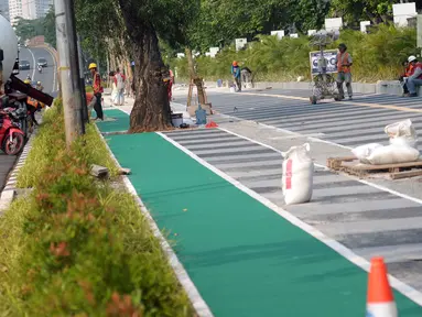Sejumlah pekerja melakukan pengerjaan tahap akhir renovasi trotoar di sekitar Jalan Gerbang Pemuda, Senayan, Jakarta, Selasa (29/5). Renovasi sebagai bagian persiapan pelaksanaan Asian Games 2018. (Liputan6.com/Helmi Fithriansyah)