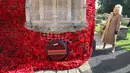Ratu Inggris, Camilla, bereaksi setelah memasang bunga poppy terakhir untuk melengkapi rangkaian 10.000 bunga poppy yang menghiasi menara gereja di Gereja St. Bartholomew di Corsham, Inggris pada Selasa 28 Oktober 2025, sebagai bagian dari kunjungannya ke The Poppy Project. (Chris Jackson/POOL/AFP)
