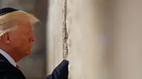 Presiden AS Donald Trump berdoa di Tembok Ratapan, tempat suci milik kaum Yahudi, di Yerusalem, Senin (22/5). Trump yang menganut Kristen Protestan, adalah presiden AS pertama yang mempunyai anggota keluarga inti orang Yahudi. (AP Photo/Evan Vucci)