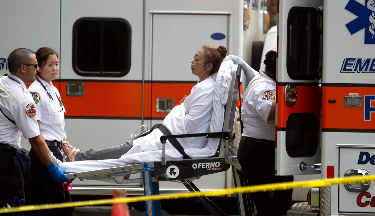 Petugas medis memberi pertolongan kepada korban kebakaran yang terjadi di apartemen Marco Polo, Honolulu (14/7). (AP Photo / Marco Garcia)