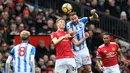 Gelandang Manchester United Scott McTominay berebut bola dengan striker Huddersfield Town Laurent Depoitre saat pertandingan Liga Inggris di Old Trafford di Manchester (3/2). MU menang 2-0 lewat gol Romelu Lukaku dan Alexis Sanchez. (AFP Photo/Paul Ellis)