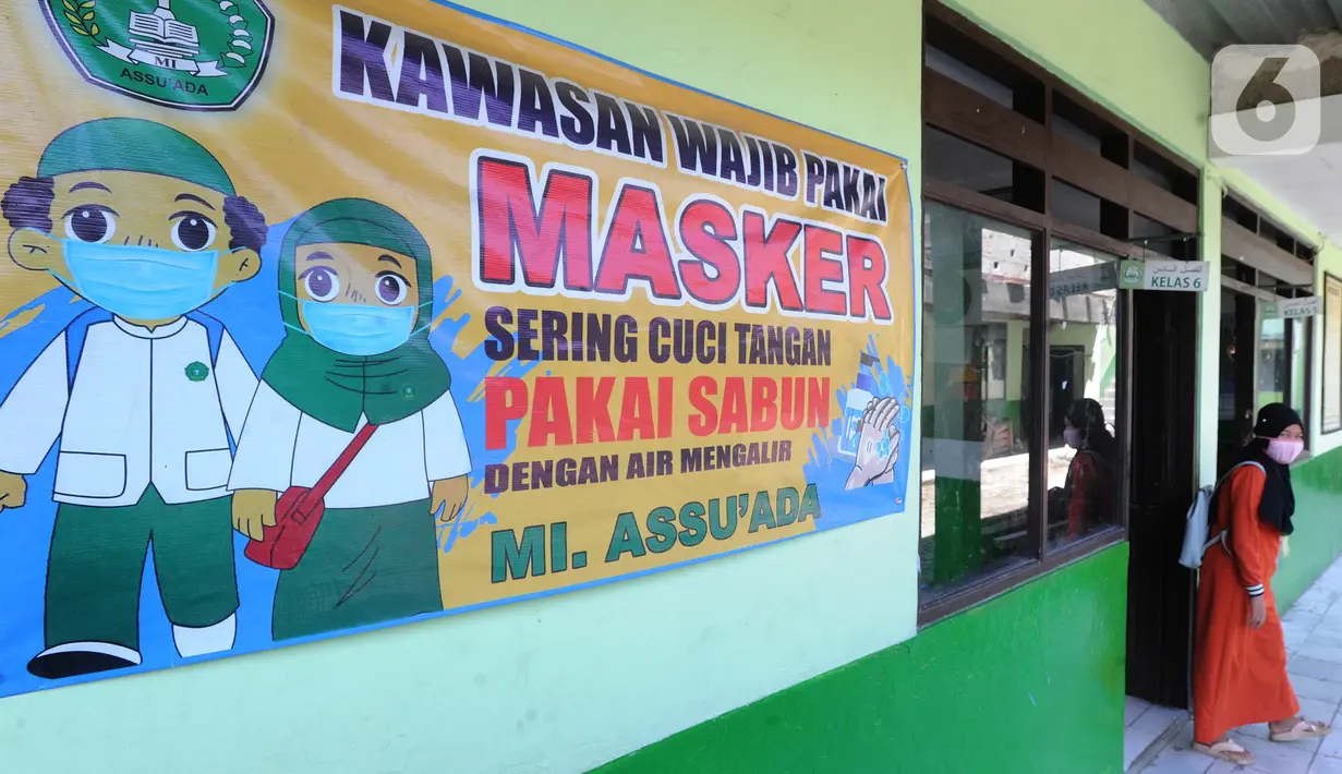 Baliho protokol kesehatan terpasang saat ujian Penilaian Akhir Semester (PAS) tahun pelajaran 2020/2021 di Madrasah Ibtidayah (MI) Assu'ada di Pancoran Mas, Depok, Jawa Barat, Selasa (1/12/2020). Ujian dilaksanakan dengan menerapkan protokol kesehatan dalam kelas. (merdeka.com/Arie Basuki)