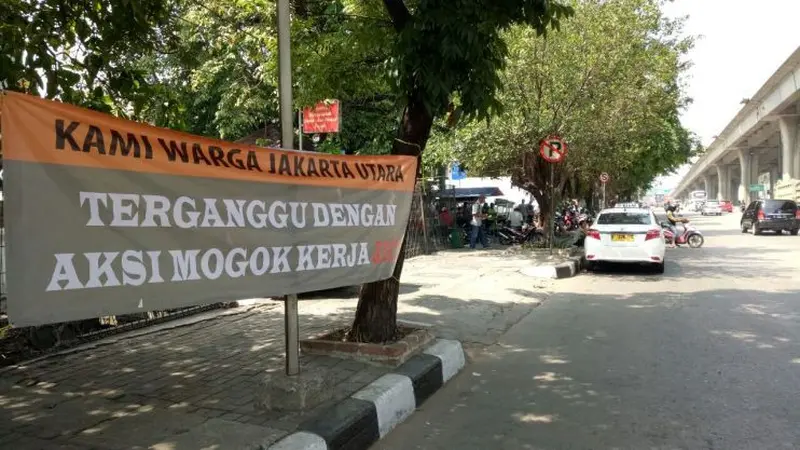 Sebuah spanduk berukuran lebar sekitar 1,5 dan panjang 5 meter mengecam aksi mogok kerja yang dilakukan para pekerja JICT. (Moch Harun/Liputan6.com)