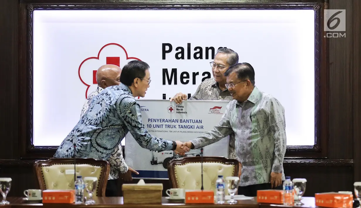 Presdir PT Astra International Tbk Prijono Sugiarto berjabat tangan dengan Ketua Umum PMI Jusuf Kalla pada acara penyerahan bantuan 10 unit truk tangki air di Kantor PMI, Jakarta, Jumat (8/2). (Liputan6.com/Fery Pradolo)