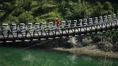 Gurman Reen Singh dari India melintasi jembatan mengikuti lomba sepeda gunung Himalaya MTB di dekat Mandi, Himachal Pradesh, India utara (4/10). Lomba sepeda ini merupakan perlombaan lintas negara tahunan ke-13. (AFP Photo/Sajjad Hussain)