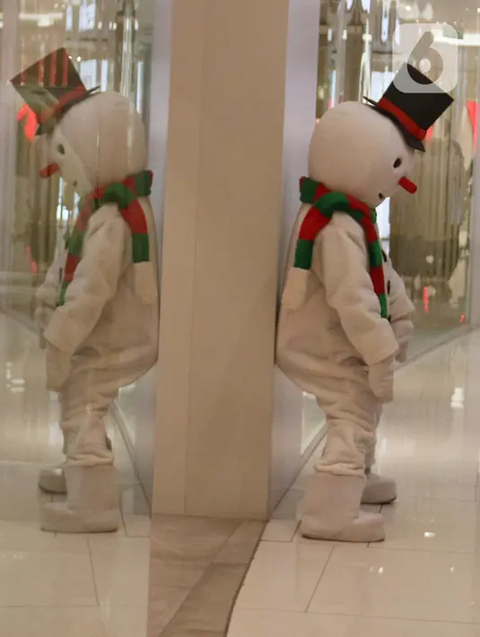 Petugas mengenakan kostum boneka salju saat menghibur pengunjung di Senayan City Mall, Jakarta, Jumat (25/12/2020). Pengunjung bisa berswafoto dan menikmati momen Natal bersama keluarga dan orang terkasih dengan "Santa and Friend". (Liputan6.com/Herman Zakharia)