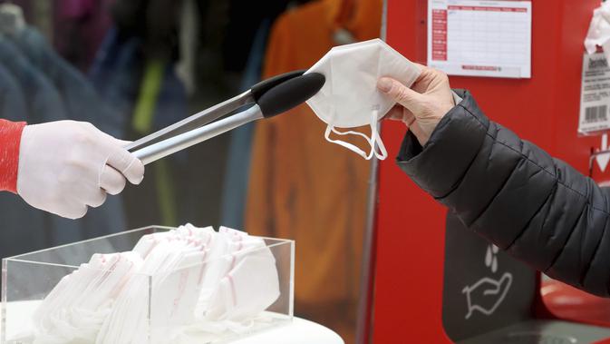 Seseorang mengambil masker FFP2 jenis respirator saat berbelanja di supermarket di Wina, Austria, Senin (25/1/2021). Mulai 25 Januari 2021, warga Austria diwajibkan mengenakan masker FFP2 di supermarket, apotek, pompa bensin, dan di transportasi umum. (AP Photo/Ronald Zak)