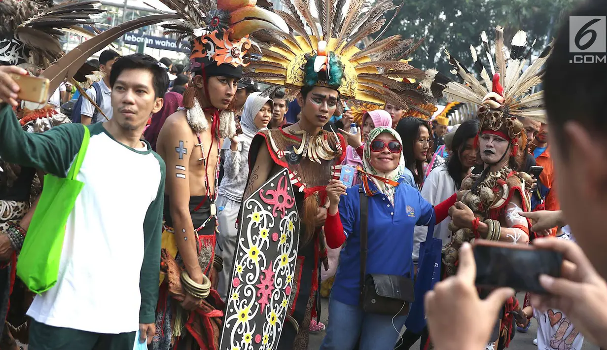 Pengunjung foto bersama kelompok seni budaya Kalimantan Selatan saat pelaksanaan car free day di Jakarta, Minggu (1/7). Pawai tersebut diadakan untuk mengenalkan budaya Kalimantan Selatan kepada masyarakat. (Liputan6.com/Immanuel Antonius)
