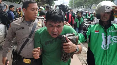 Petugas kepolisian mengamankan terduga copet menuju Mapolda Metro Jaya di Jalan Jenderal Sudirman, Jakarta (2/4). Pelaku tertangkap tangan oleh korbannya saat mencopet handphone di jembatan penyeberangan orang (JPO). (Merdeka.com/Arie Basuki)