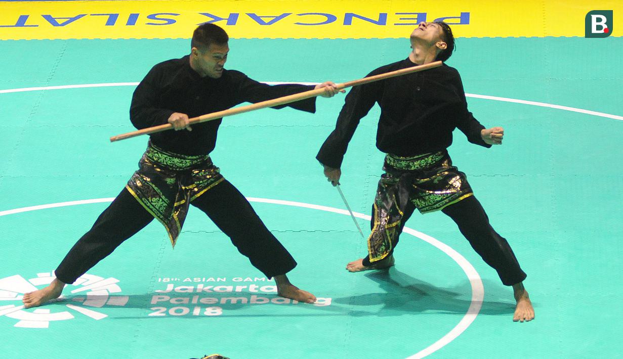 Pesilat Indonesia Hendy dan Yolla Primadona, saat beraksi pada pencak silat nomor artistik ganda putra Asian Games di TMII, Jakarta, Senin (27/8/2018). Hendy dan Yolla mendapat mendali emas dengan nilai 580. (Merdeka.com/Arie Basuki)