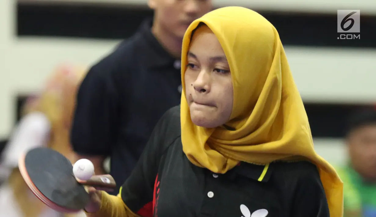 Petenis meja difabel Indonesia, Leli Marlina melakukan serve saat melawan Bee Tin Toh (Singapura) pada Indonesia Para Games Invitational Tournament 2018 di GBK Arena, Jakarta, Minggu (1/7). Leli unggul tiga set langsung. (Liputan6.com/Helmi Fithriansyah)